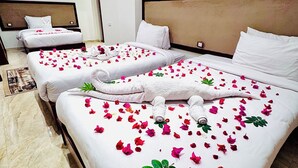 A hotel room with two beds, each adorned with rose petals and white towels. - Flower Pyramids Inn (Giza)