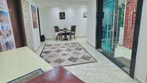 A spacious room with a wooden table, a patterned rug, and a dining table with chairs. - Flower Pyramids Inn (Giza)