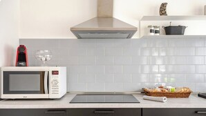 Eine moderne Küche mit Mikrowelle, Toaster und einem Brotkorb auf der Arbeitsfläche.