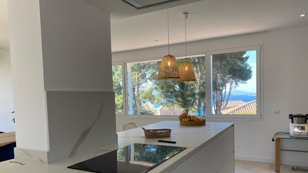 A modern kitchen with a central island, large windows, and a view of the outdoors. - Sea views, located 600 meters from the beach.  Garden, pool, and A/C. (Sa Riera)