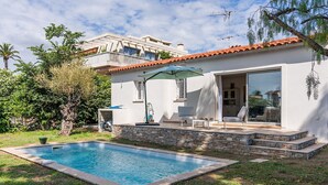 A modern house with a swimming pool, outdoor seating, and a stone wall. - Pretty house with pool in Cagnes-sur-Mer (Cagnes-sur-Mer)