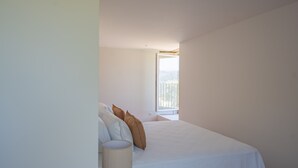 Ein Schlafzimmer mit einem Bett, Kissen und einer Lampe.