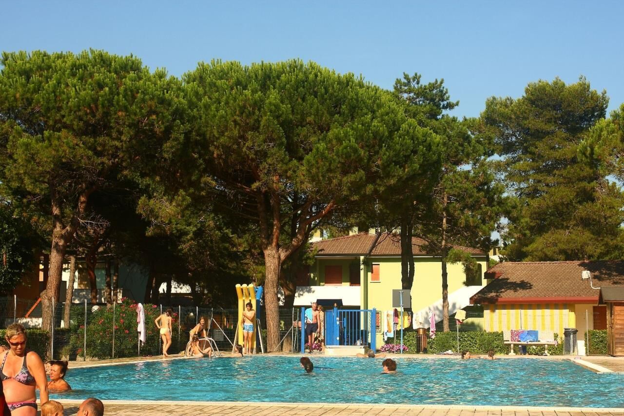A swimming pool surrounded by trees and buildings.
