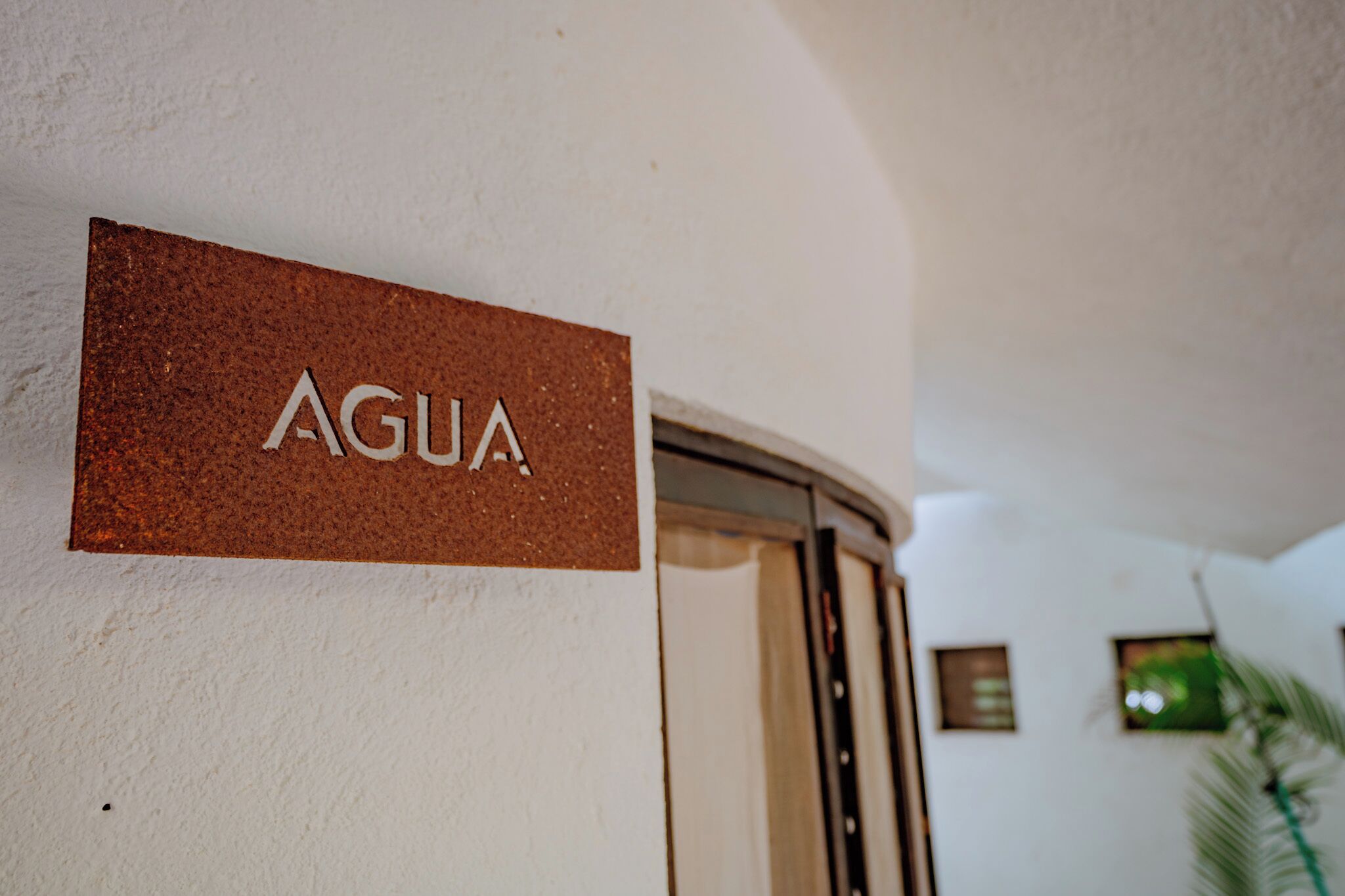 Un letrero con la palabra 'AGUA' en una pared.