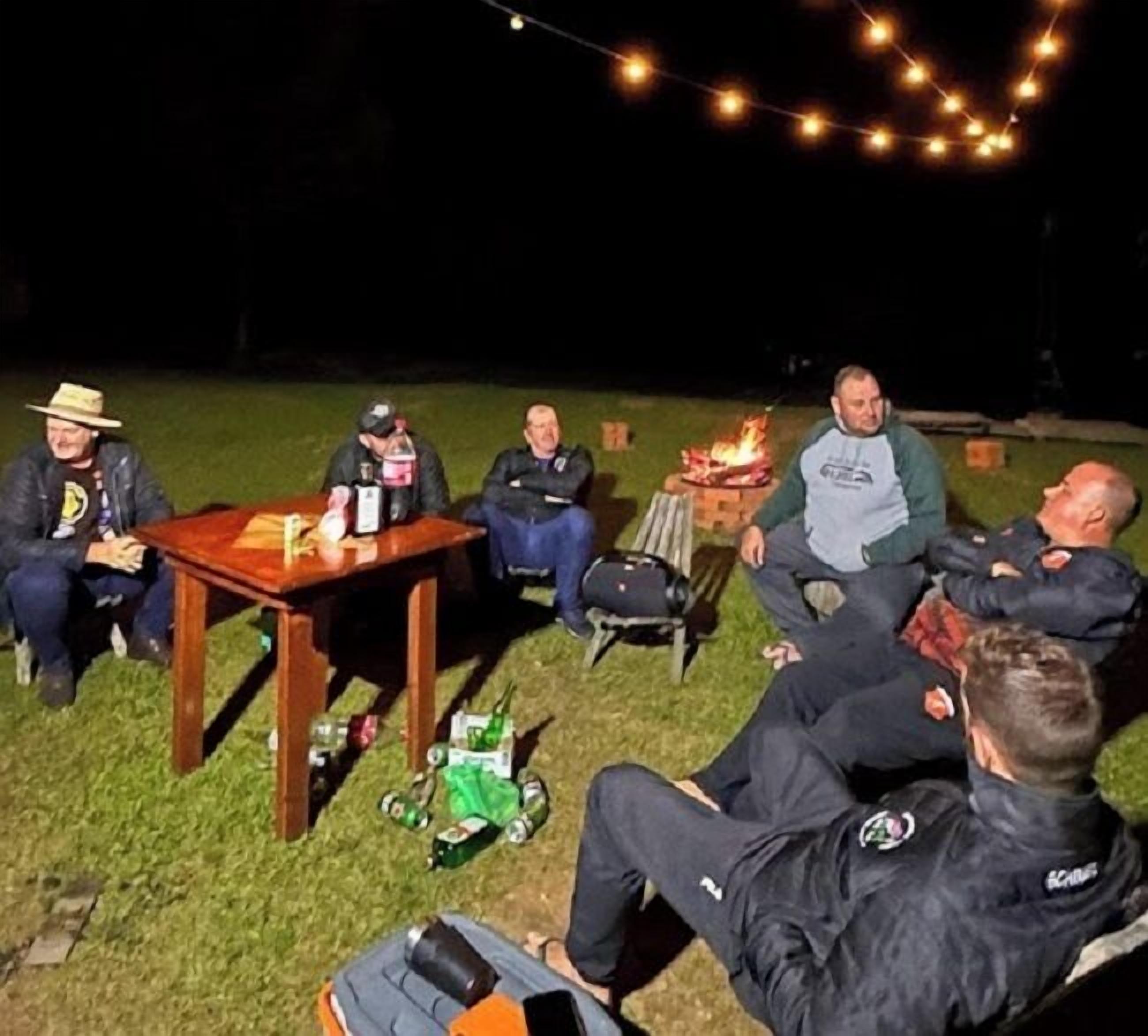 A group of people gathered around a campfire at night.