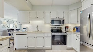 A modern kitchen with white cabinetry, stainless steel appliances, and a built-in oven. - Fully updated 2025 Dream Oceanfront Sunset View. 2/2 Sleeps 8 (Fort Walton Beach)