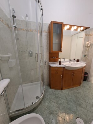 Een douche, een haardroger, een bidet, handdoeken