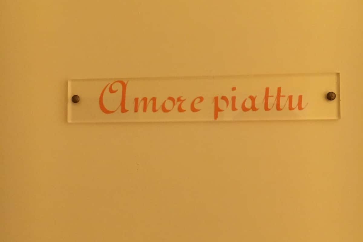 A sign with the text 'Amore piatti' on a wall.