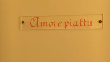 Un cartello con la scritta 'Amore piatti' su un muro.