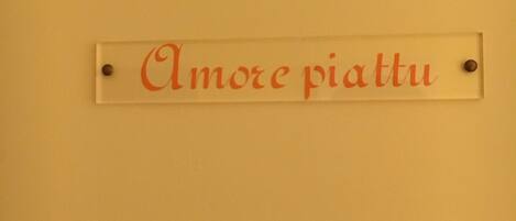 Una señal con el texto 'Amore piatti' en una pared.