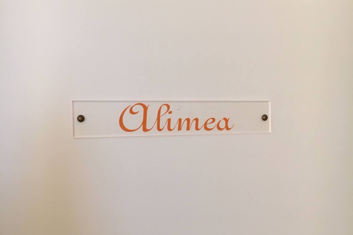 A white wall with a nameplate that reads "Alimea".
