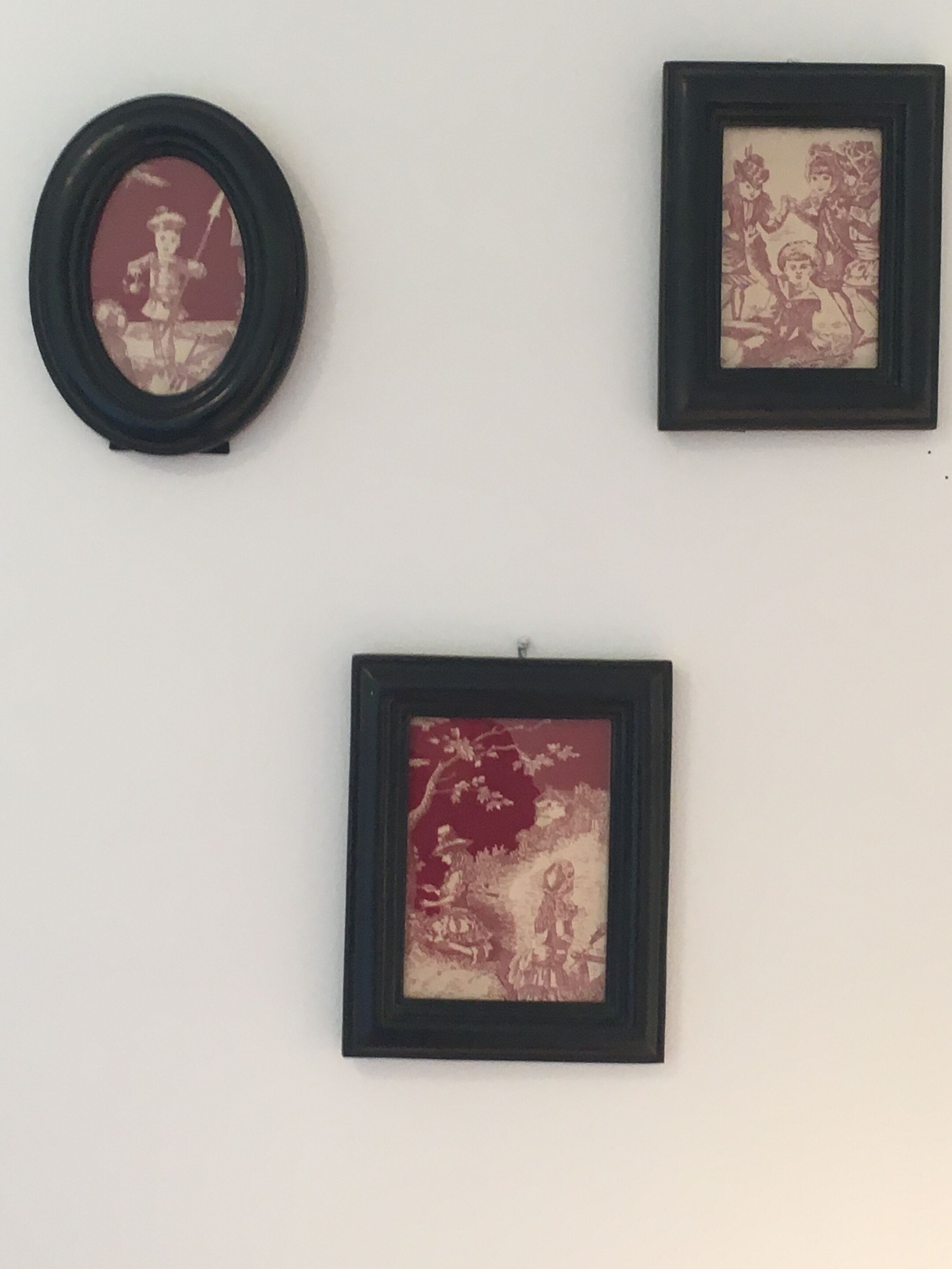Three framed artworks on a wall.