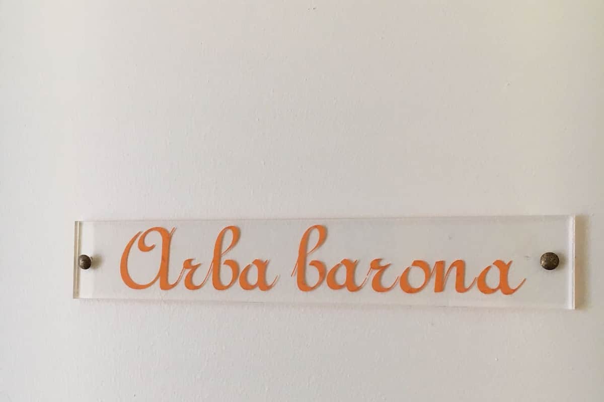 A sign with the text "Arba barona" mounted on a wall.