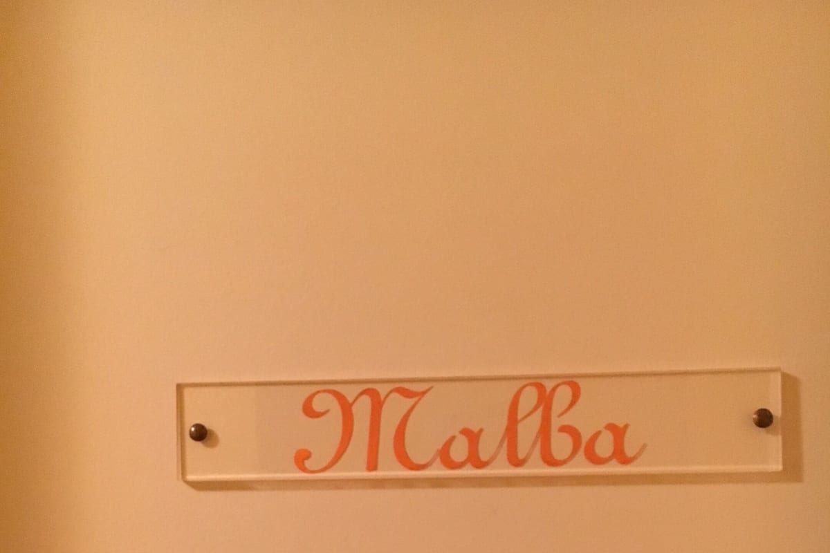 A nameplate with the name "Malba" mounted on a wall.