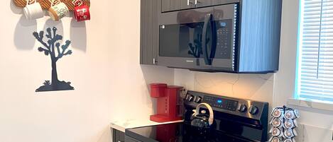 A modern kitchen with a built-in microwave, oven, and coffee maker.