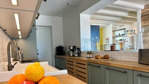 A modern kitchen with a wooden countertop, a bowl of fruit, and a coffee maker. - Villa Ker Tesson: Private Jacuzzi, Port 700m, Fisherman's House, 10 guests (L'Île-d'Yeu)