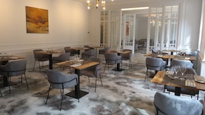 A dining area with tables set for service, chairs, and a chandelier. - Le Relais de Montignac (Montignac)