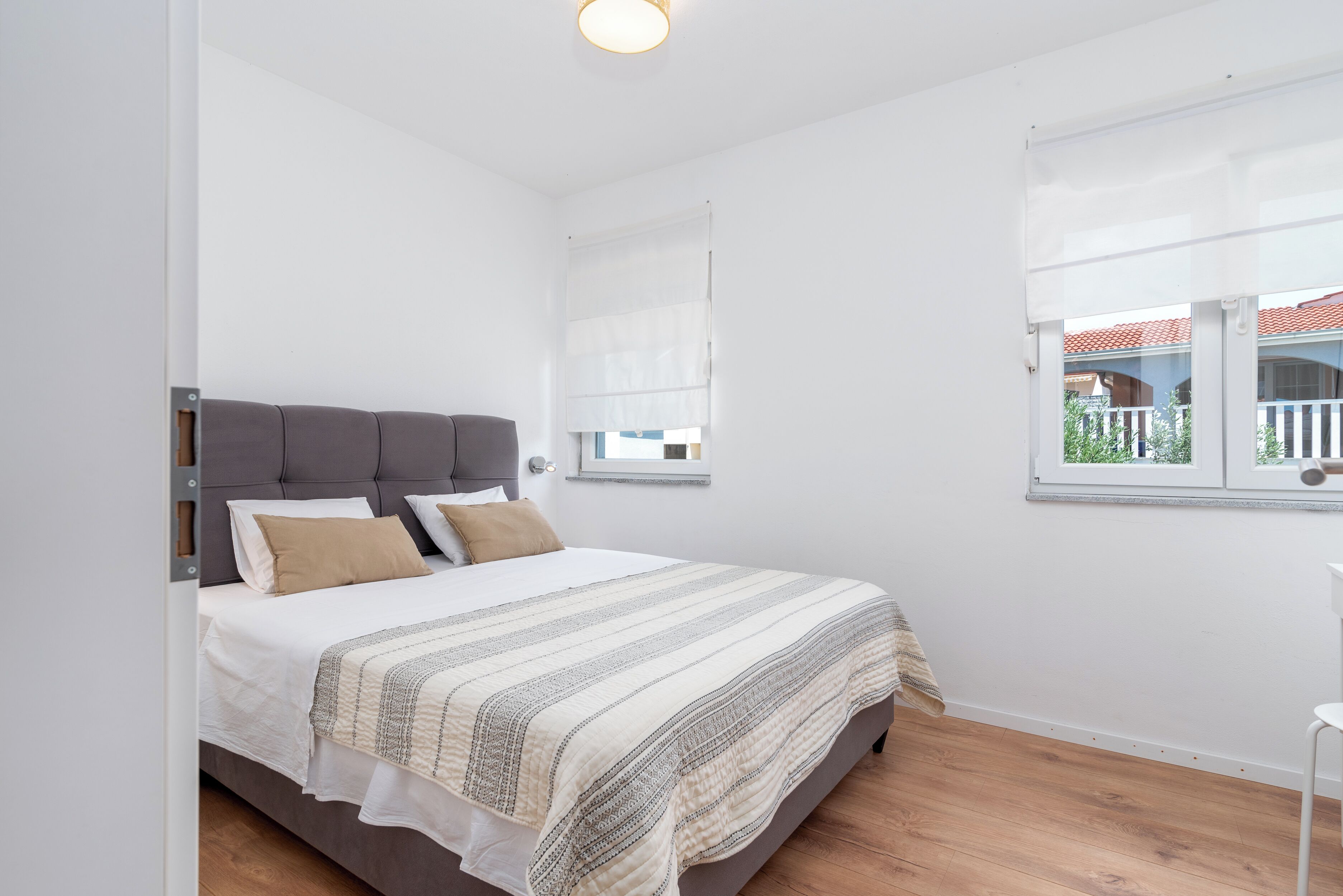 Een slaapkamer met een bed, een raam en uitzicht.