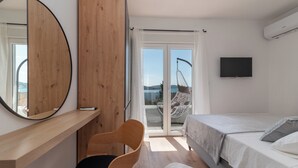 A modern bedroom with a bed, a chair, a desk, a television, and a view of the outdoors. - Villa Eight by D (Okrug)
