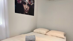 A hotel room with a bed, two pillows, and a rolled-up towel on the bed. - Park View Studio - Features Free Wifi, Bright Furnishings and Modern Facilities (Nijmegen)