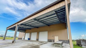 Un grand bâtiment industriel doté d’un quai de chargement couvert et de plusieurs portes de garage.