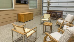 Un espace extérieur lumineux, aménagé avec du mobilier en bois, un buffet en bois et une grande fenêtre.