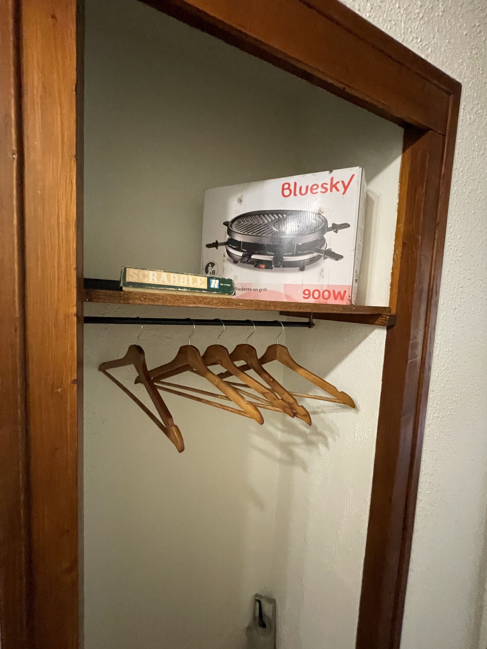 Ein hölzerner Türrahmen mit Ablage darüber. Auf der Ablage befindet sich eine Schachtel mit der Aufschrift 'Bluesky 900W' und ein kleines grünes Objekt. Darunter sind Holzaufhänger angebracht.