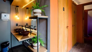 A modern bathroom with a wooden vanity, multiple sinks, and a towel rack. - Island Vibe Nomads - Adventure Hostels (Florianópolis)