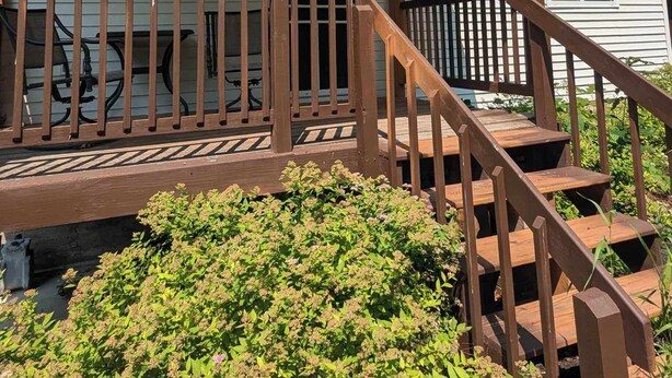 Een gelijkvloerse stacaravan met een houten terras en een veranda.