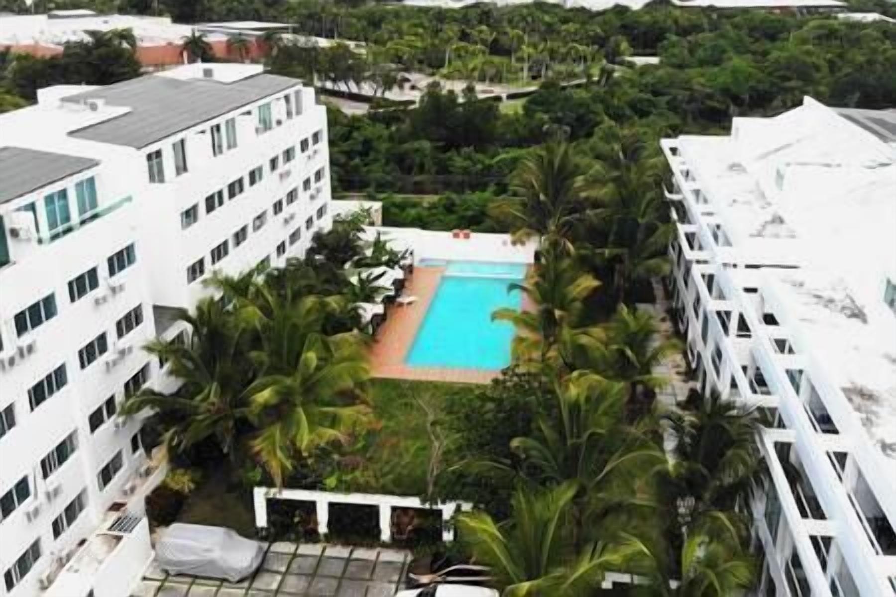 A high-rise hotel with a rooftop pool surrounded by palm trees.