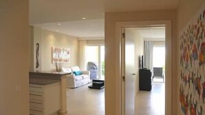 A spacious living area with a sofa, a coffee table, and a painting on the wall.