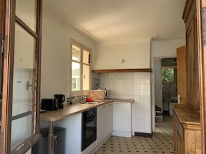 Cozinha compacta com lava-louças, forno e janela.