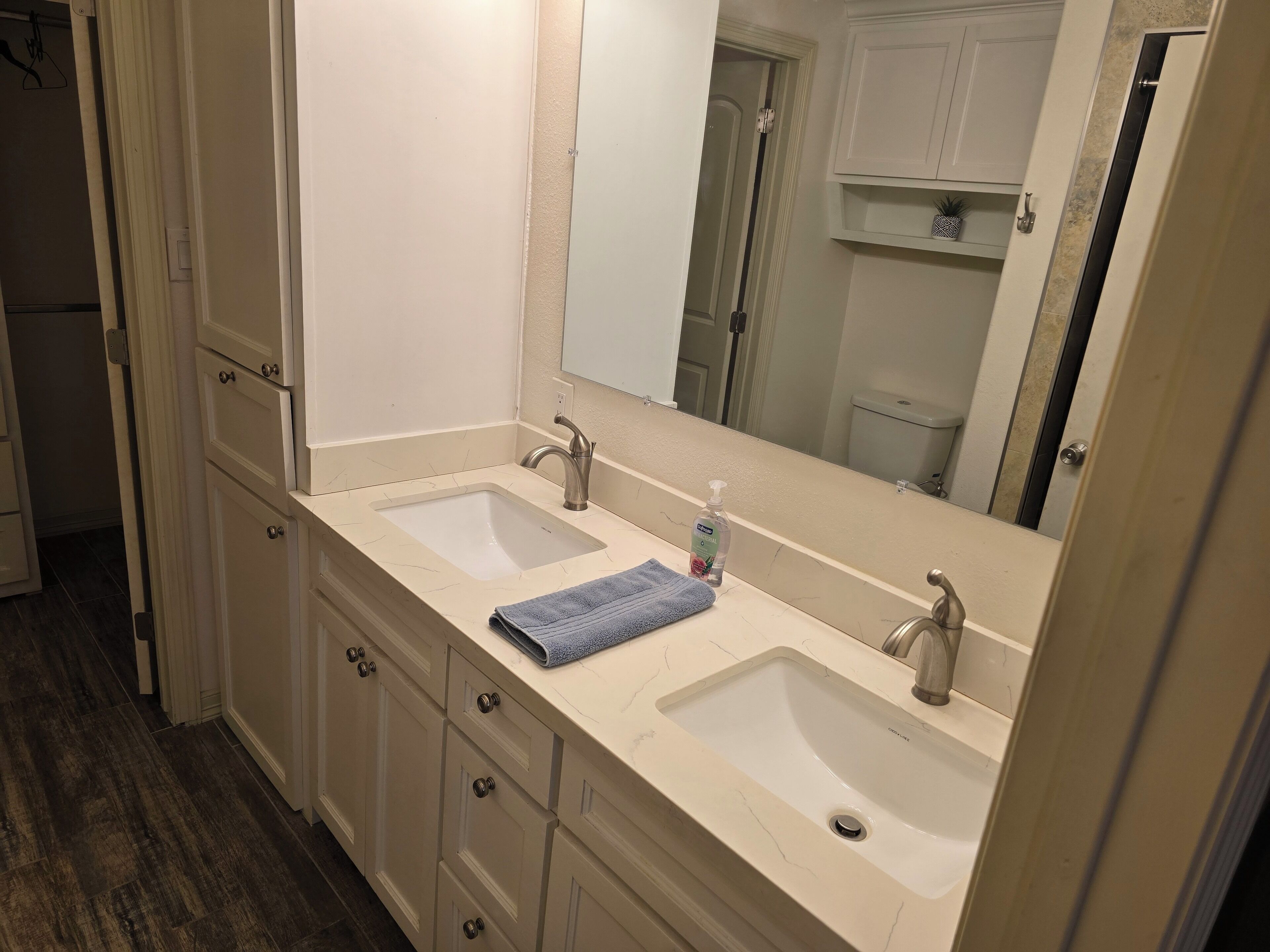 Une salle de bain avec deux lavabos, un miroir et une serviette posée sur le comptoir.