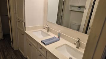 A bathroom with two sinks, a mirror, and a towel on the counter.