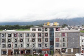 A multi-story building with a flat roof, multiple windows, and signage. - Yiyuan Impression Inn (Eryuan)