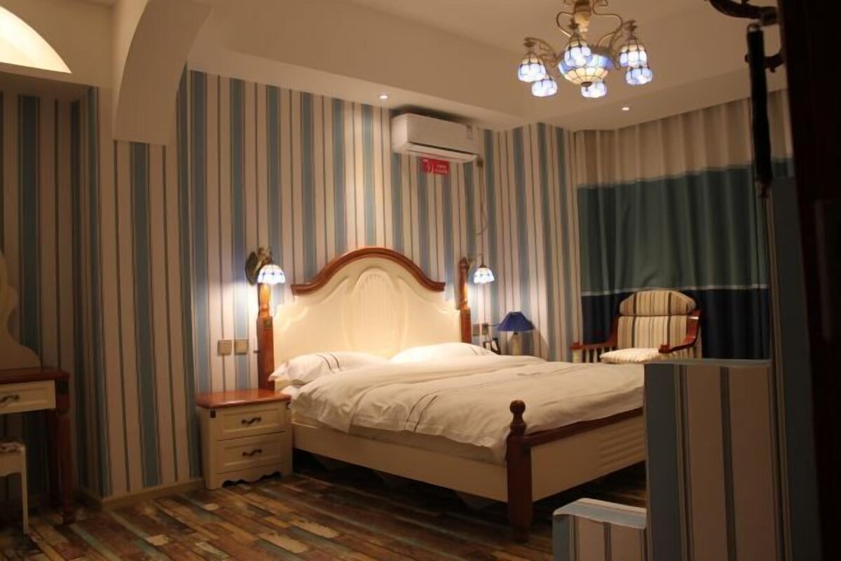 A bedroom with a bed, bedside tables, a chair, and a lamp.
