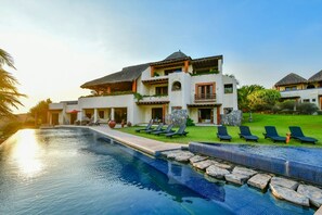 Relax by the resort's large pool surrounded by lounge chairs and a lush lawn.