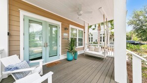 A covered porch with white furniture, a ceiling fan, and a view of the street. - Town of Prominence- Just Beachy (Santa Rosa Beach)