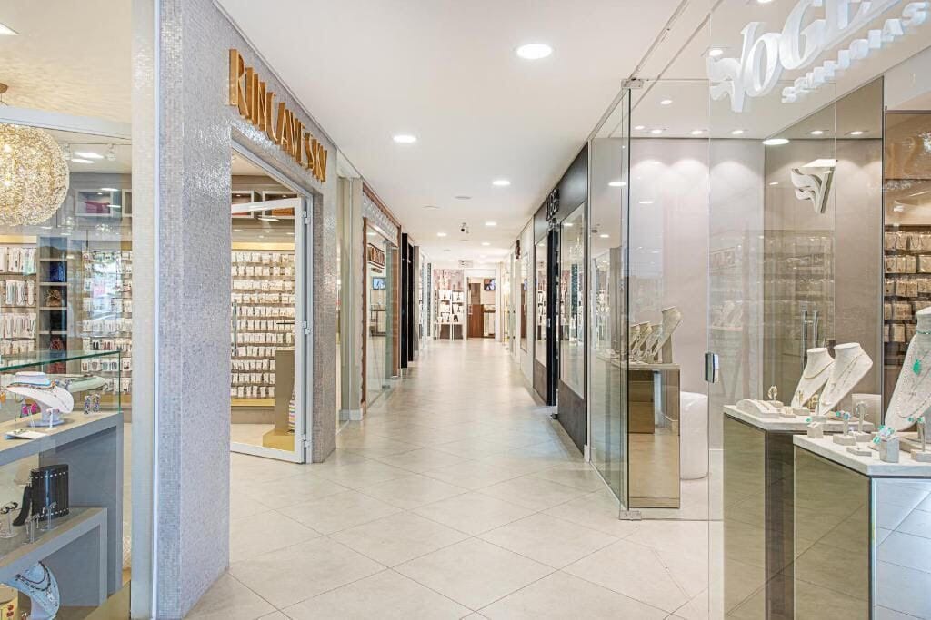 A shopping corridor with glass-fronted jewelry stores and a central walkway.