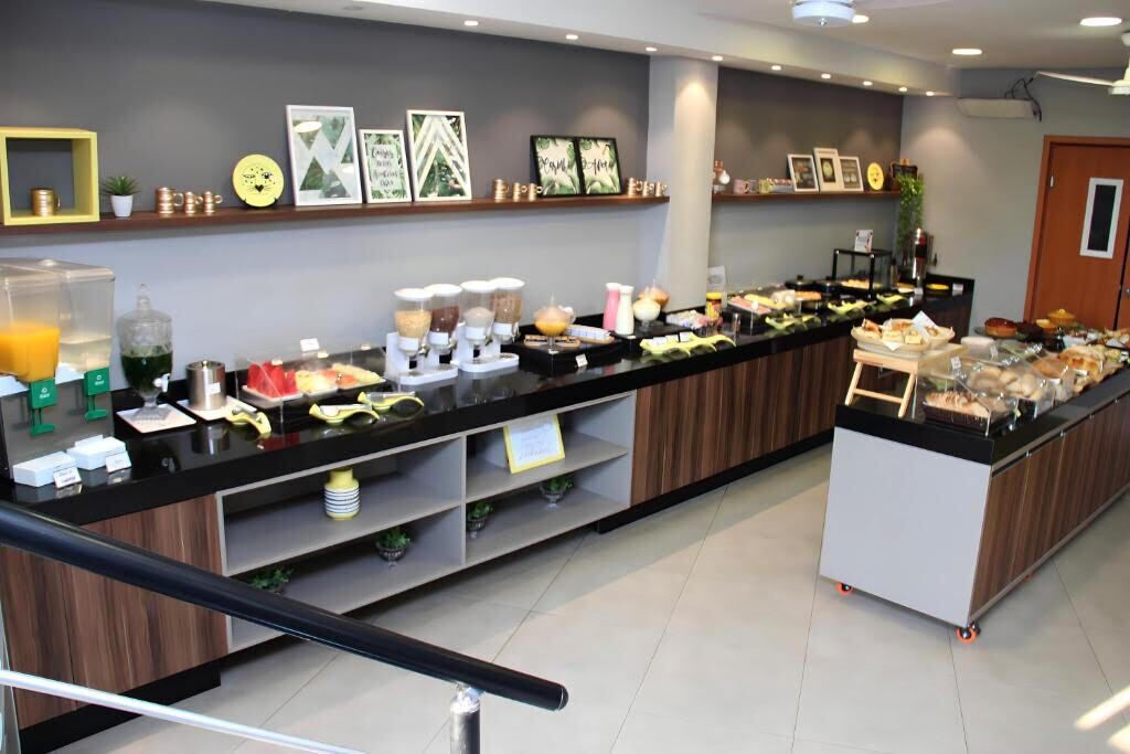 A buffet area with various food items and beverages, a coffee station, and decorative wall art.