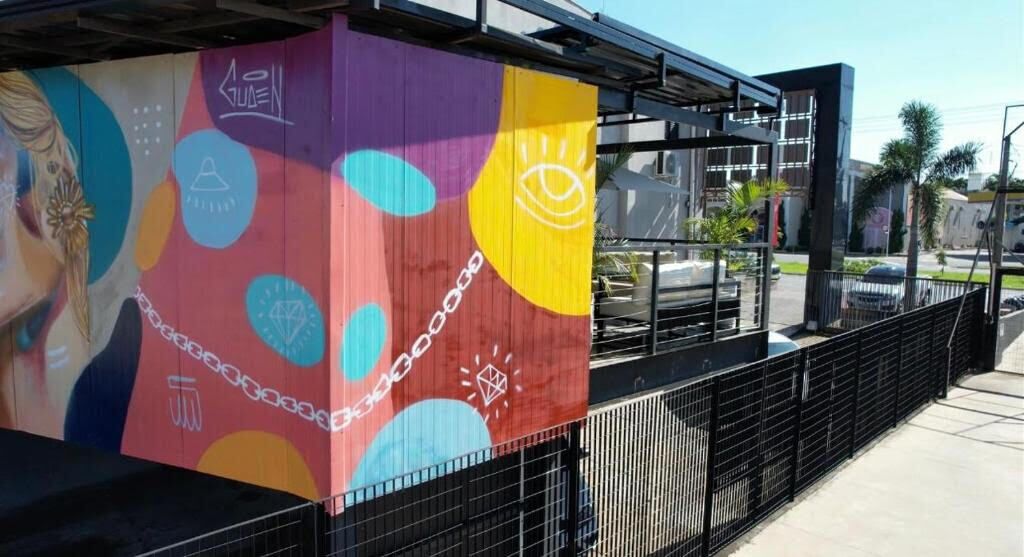 Un mural colorido en la fachada de un edificio con diseños y símbolos abstractos.