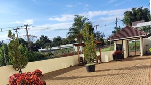 A rooftop patio with a brick floor, potted plants, and a pergola. - Apartamento Completo Mobiliado com ar Condicionado Quente Frio (Country Cascavel)