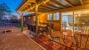 An outdoor patio area with a covered seating area, a table, and chairs. - Hilltop Private Resort Home with SPARKLING POOL (Tucson)