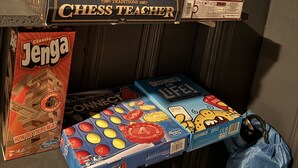 En hylde med forskellige brætspil, herunder UNO, Skaklærer, Jenga og Connect 4.