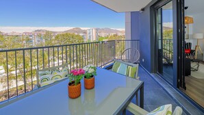 A balcony with a table, chairs, and potted plants. - Cubo's Urban Sky Terrace View Apartment / urban / air conditioning / free wifi / community pool (Málaga)