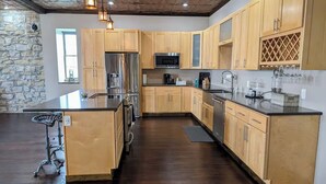 A modern kitchen with wooden cabinets, stainless steel appliances, and a large island.