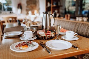 A dining table set with plates, cutlery, a pitcher, and glasses. - Waldhotel Weitblick (Frankenblick)
