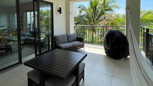 A balcony with a table, chairs, a sofa, and a hammock. - Harmony Lush Refuge 3BR Laguna (Río Hato)