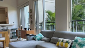 A modern living room with a grey sectional sofa, a wooden coffee table, and a patterned rug. - Harmony Lush Refuge 3BR Laguna (Río Hato)