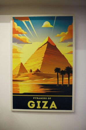 A poster of the Pyramids of Giza with pyramids, palm trees, and a sunset.